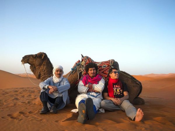 Local Berber guide with camel in the Moroccan Sahara desert. Local Berber guide with camel caravan Berber guide leading a camel caravan in the Moroccan Sahara desert.